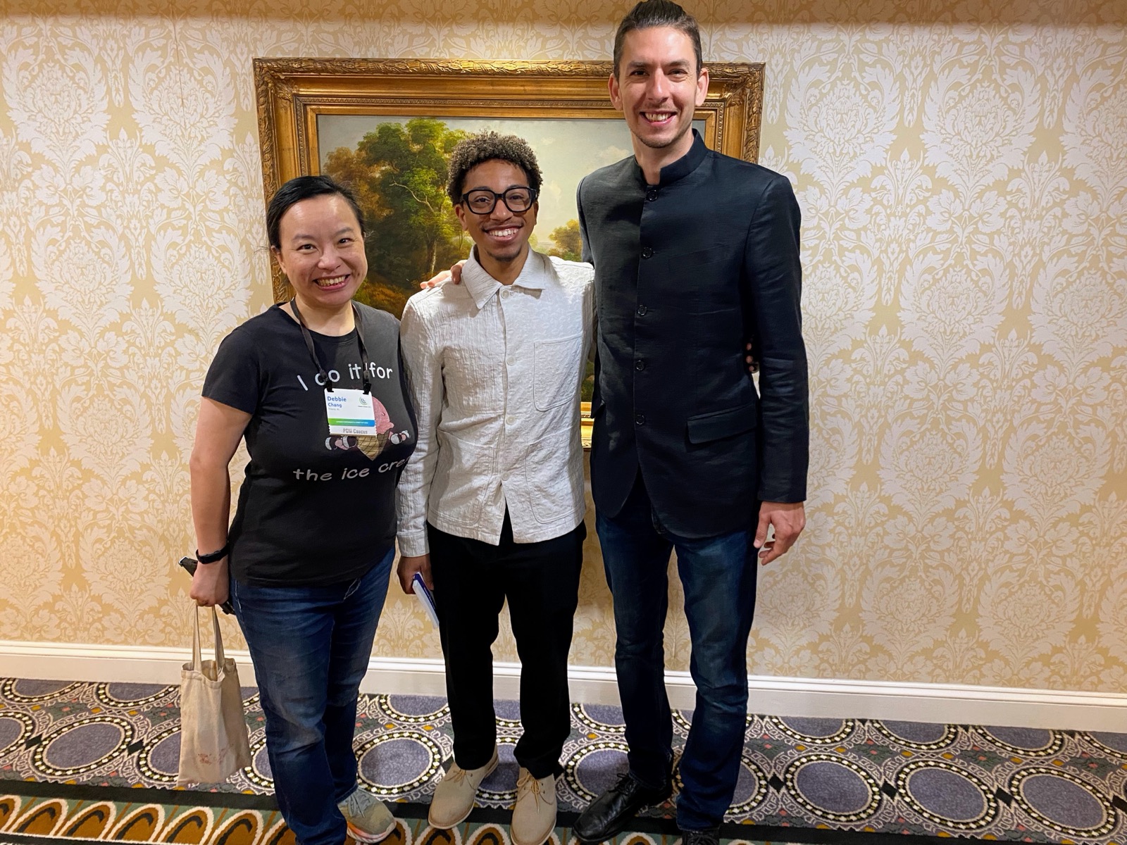 Three PGM volunteers posing together in a conference hallway