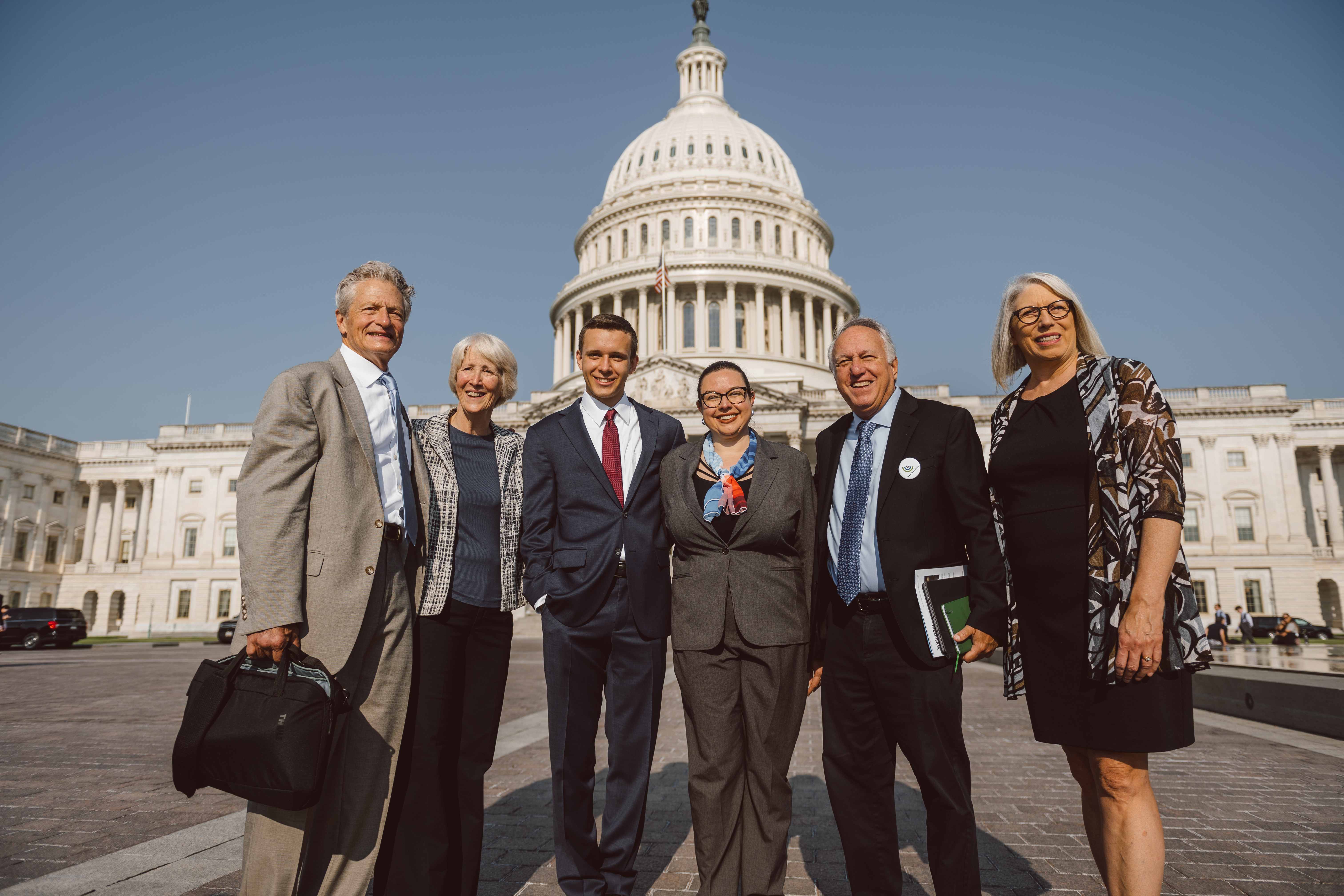 A group of CCL volunteers in business attire in front of the U.S. Capitol