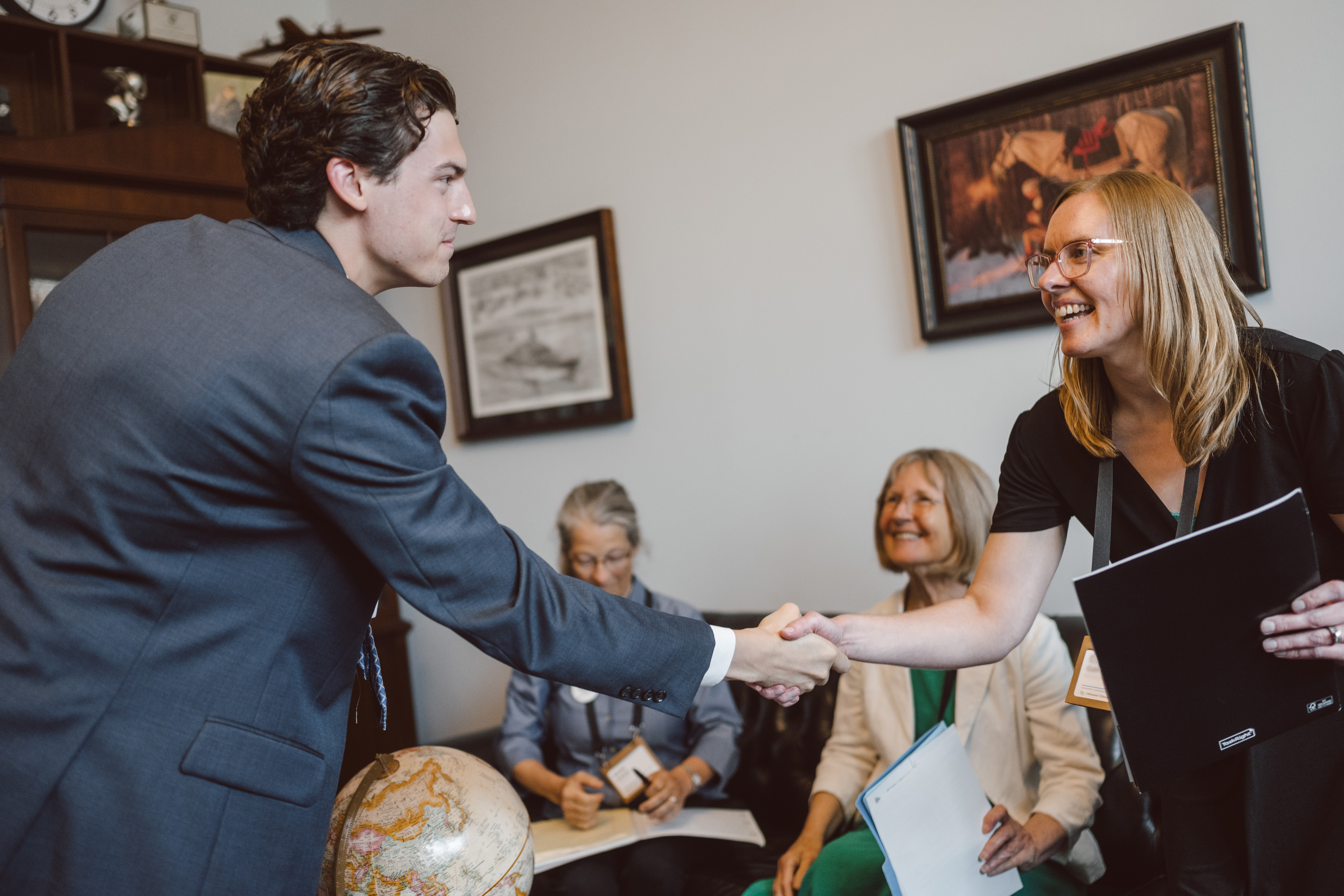 A CCL volunteer shaking hands during a meeting in a congressional office