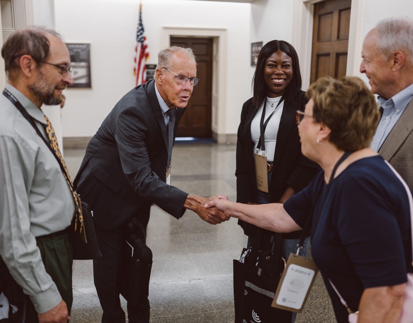 CCL volunteers shaking hands and talking together in a Capitol Hill hallway