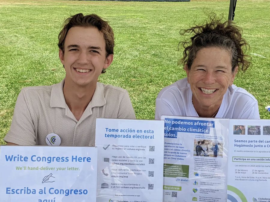 Two volunteers tabling with Write Congress Here signs