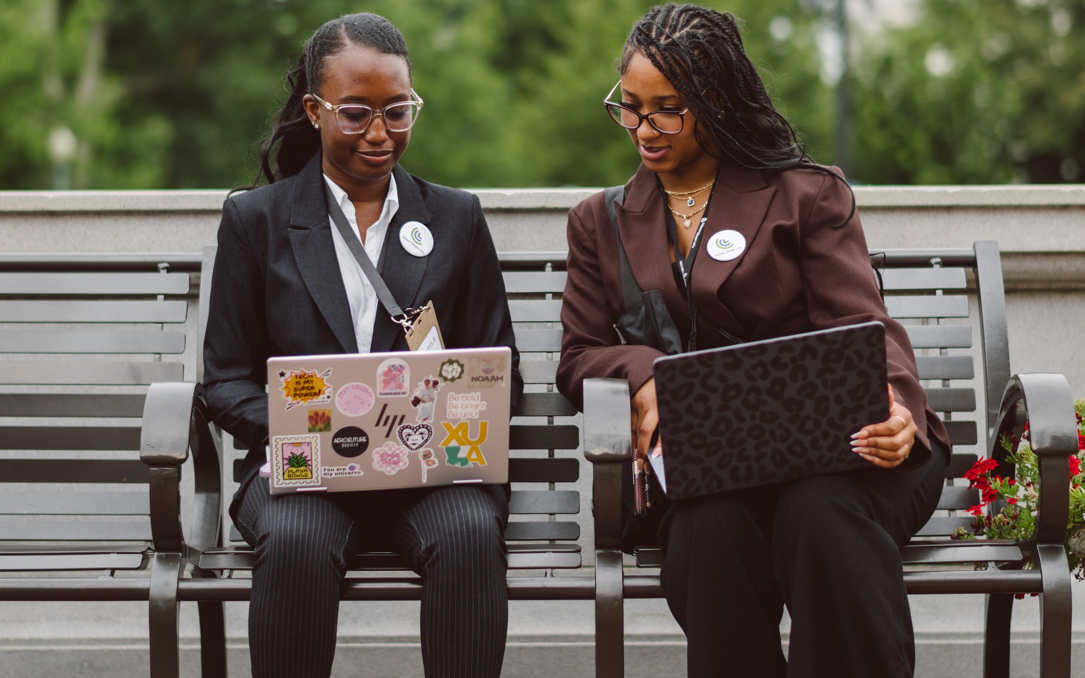 Two CCLers on a bench with laptops open, joining the Inclusion Conference