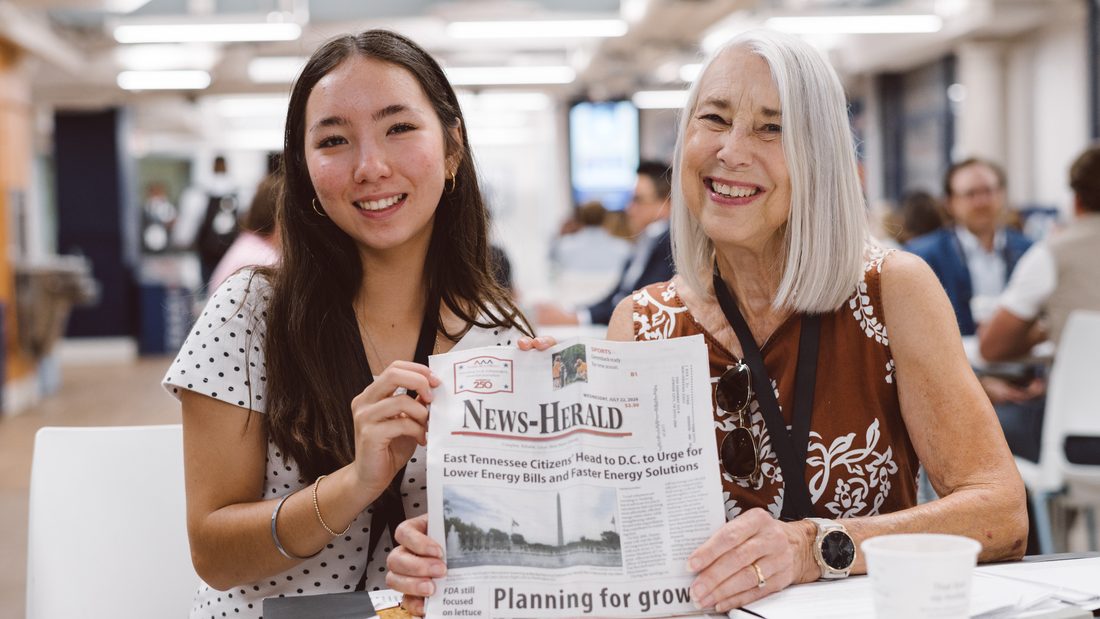 Two CCL volunteers holding up a local newspaper carrying their letter