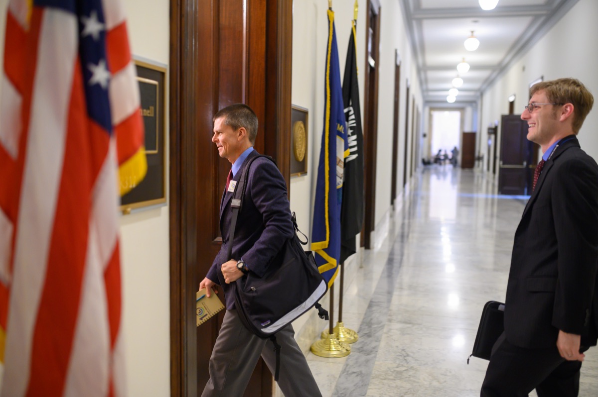 A volunteer walks into a Member of Congress's office, flag in the foreground